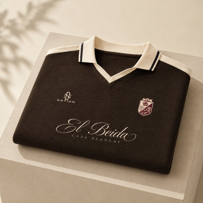 Polo El Beida à bandes marron plié, script écru visible