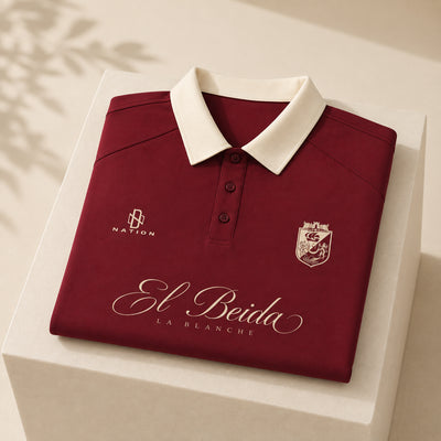 Polo El Beida bordeaux plié, script doré visible