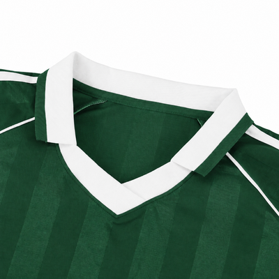 Close-up of the white V-neck of the green piped Djazaïr jersey